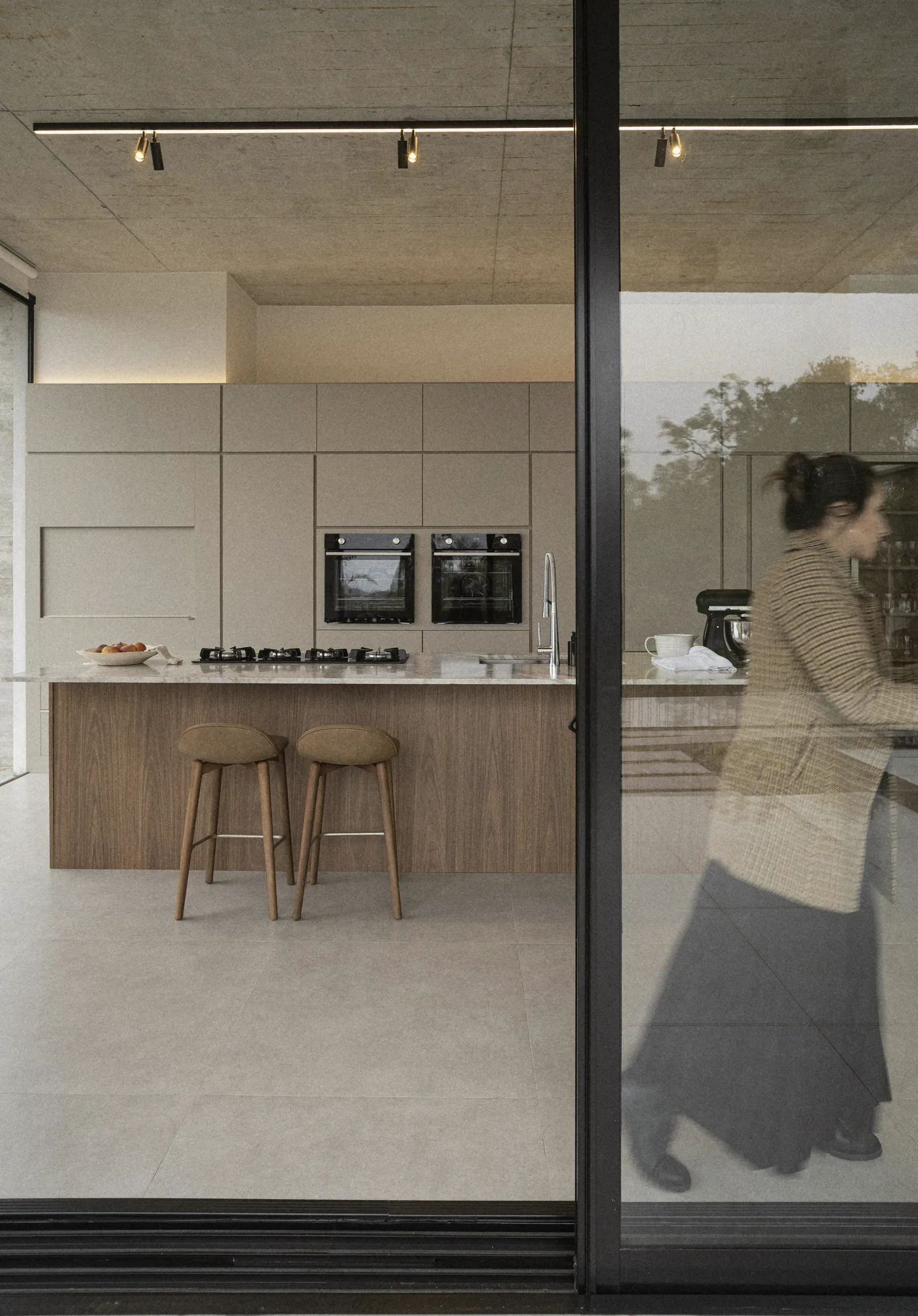 A woman at the glass door, the island beyond