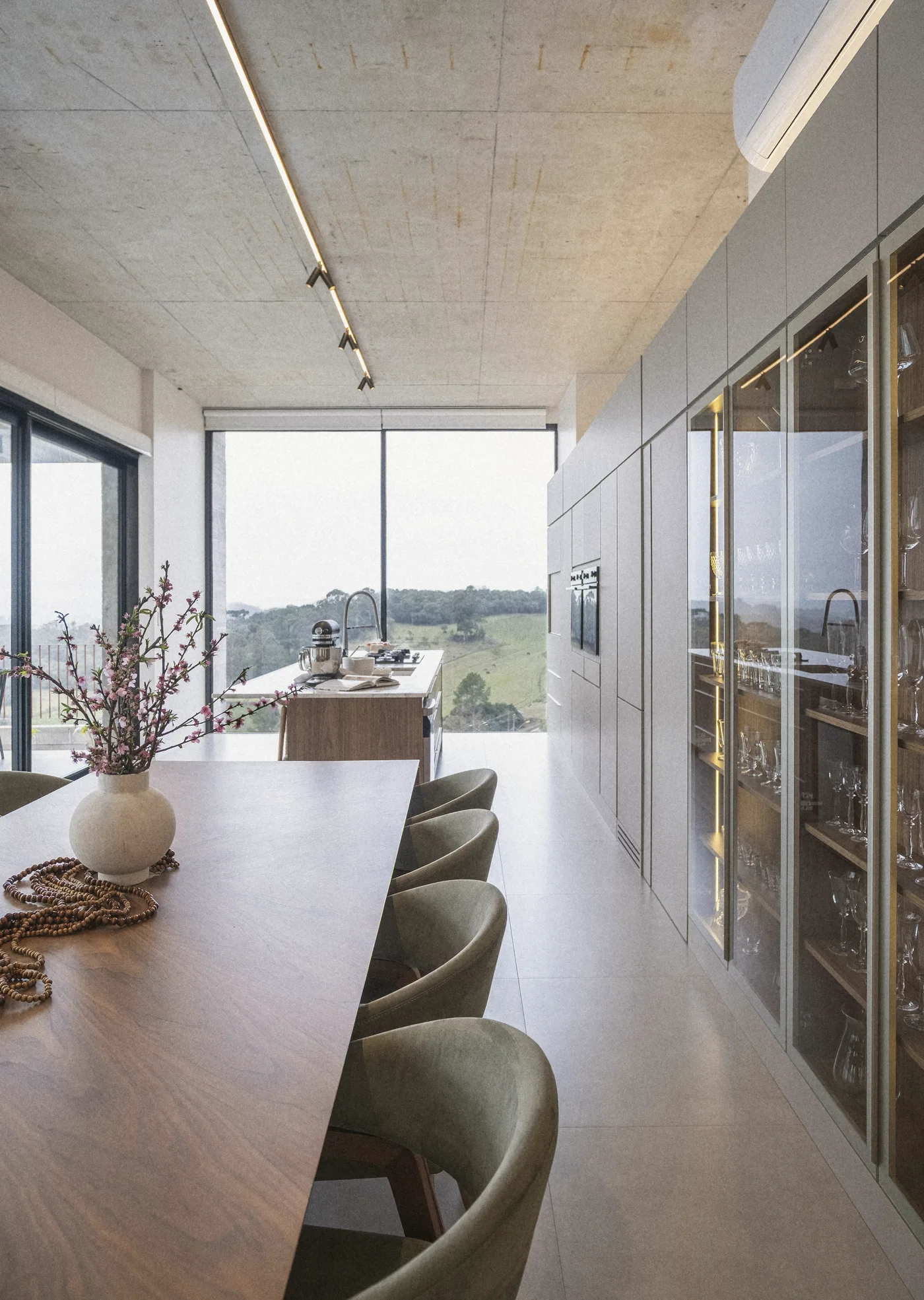 A vase on the long walnut table by the cabinets