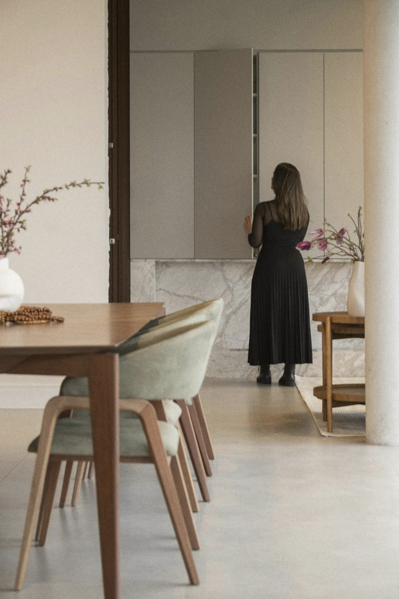 The pantry wall, a woman at its tall doors