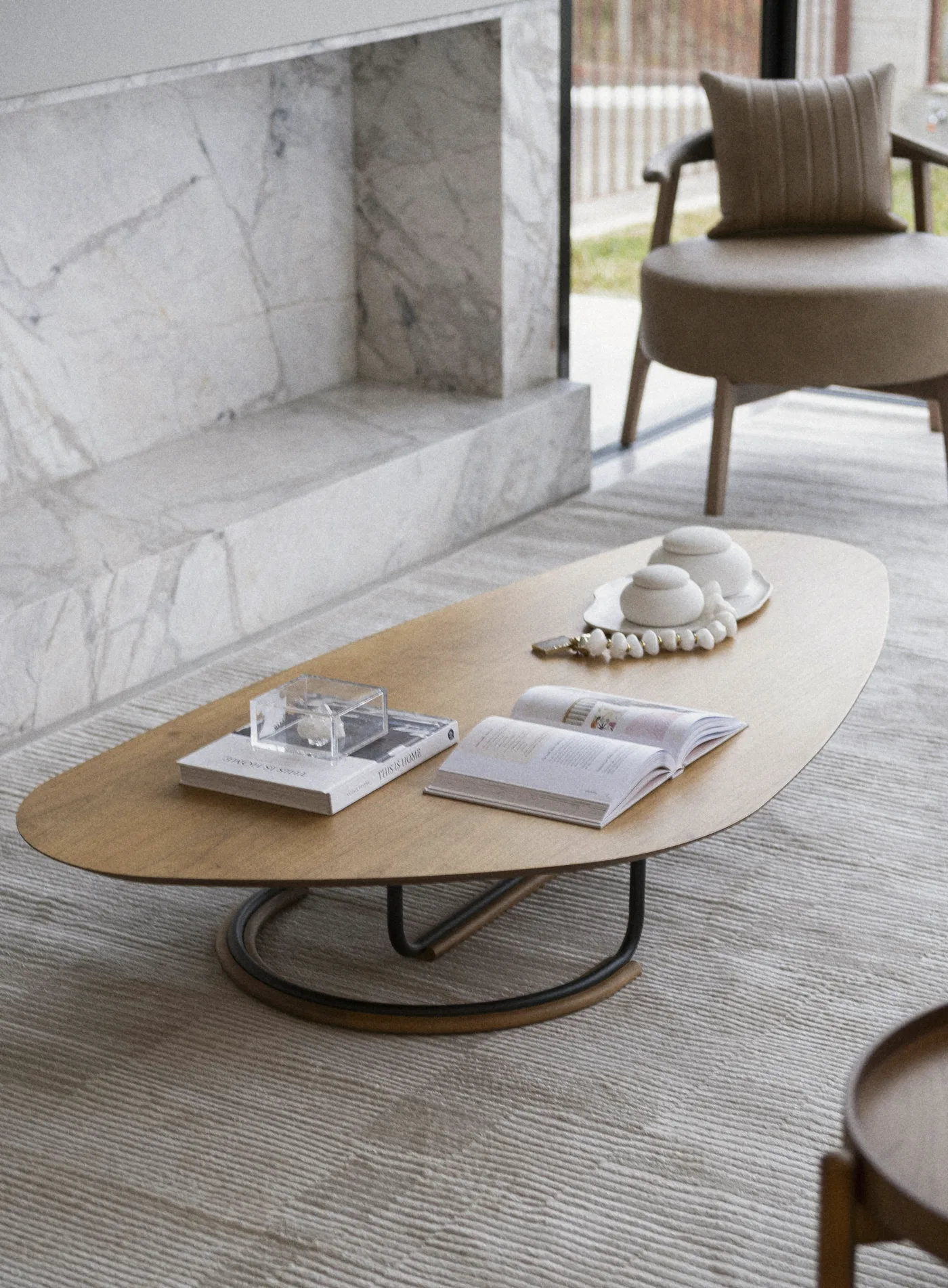 An oval walnut table before the marble fireplace